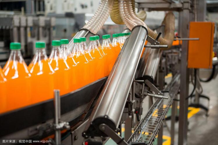工厂生产线上的橙子饮料瓶